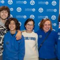 Family of six posing together by the Alumni Relations backdrop.